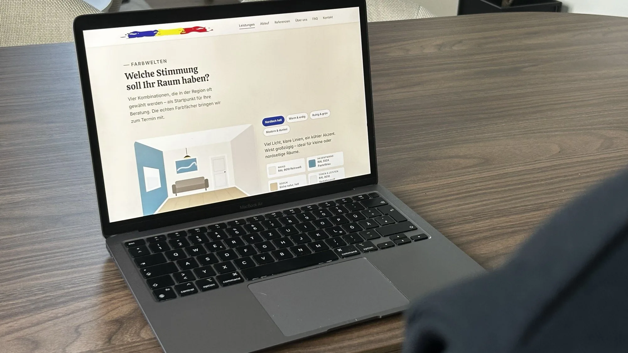 Laptop auf einem Tisch, auf dem Bildschirm die Farbwelten der Seite von Malerbetrieb Viktor Hirt